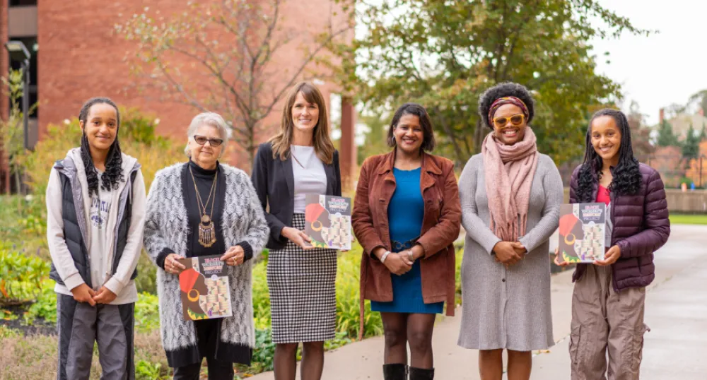 Recognizing Women’s History Month 2023 image of six people standing shoulder to shoulder if font of a brick building