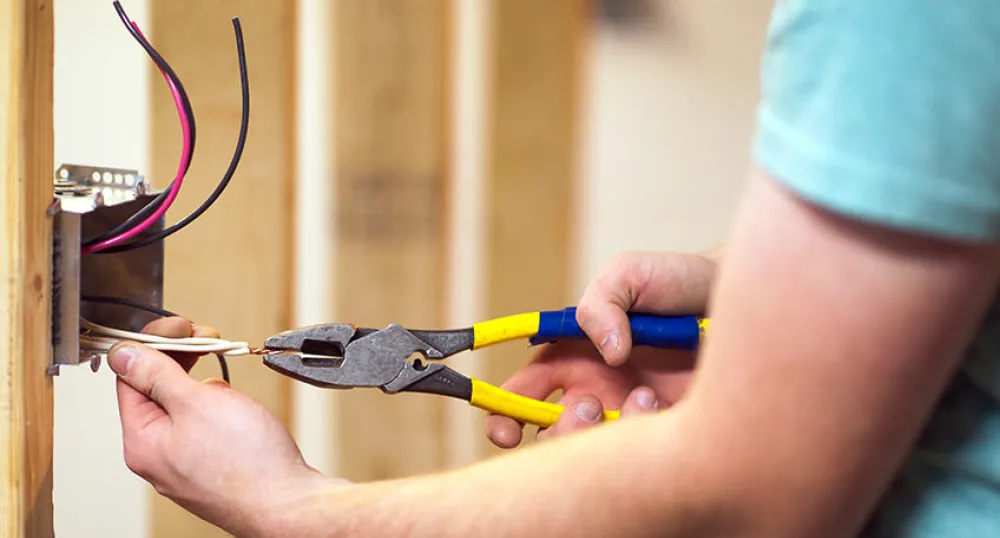 electrical contractor PEI Image of male electrical contractor wiring an outlet