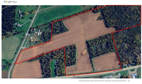 An aerial photo of the newly acquired land; currently farmland and partial forest.
