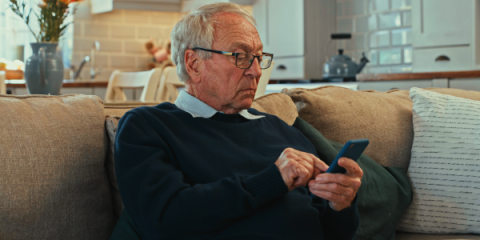 senior man looking at his phone