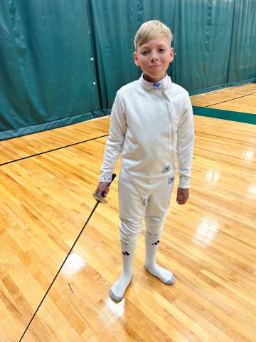 image of a young person in a gymnasium wearing sport of fencing equipment 