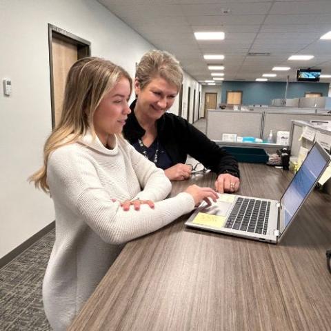 image of two people looking at a computer in a hospital nurse station