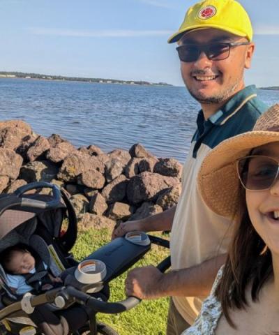 image of a couple walking their stroller and baby along the waterfront