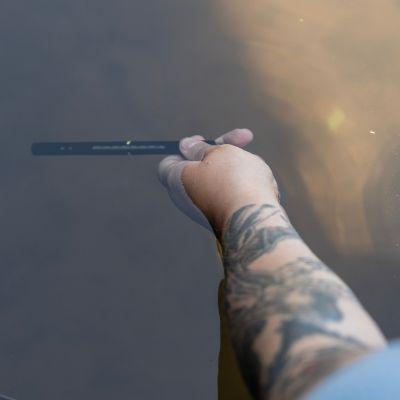 image of a person taking a river&#039;s water temperature