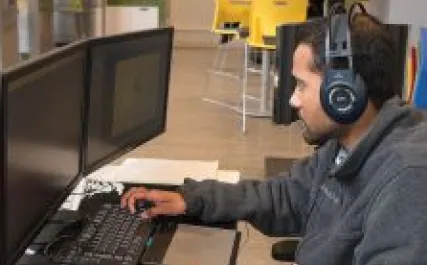 Young male works at computer station at Startup Zone PEI
