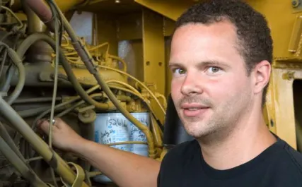 Male heavy duty mechanic working on engine