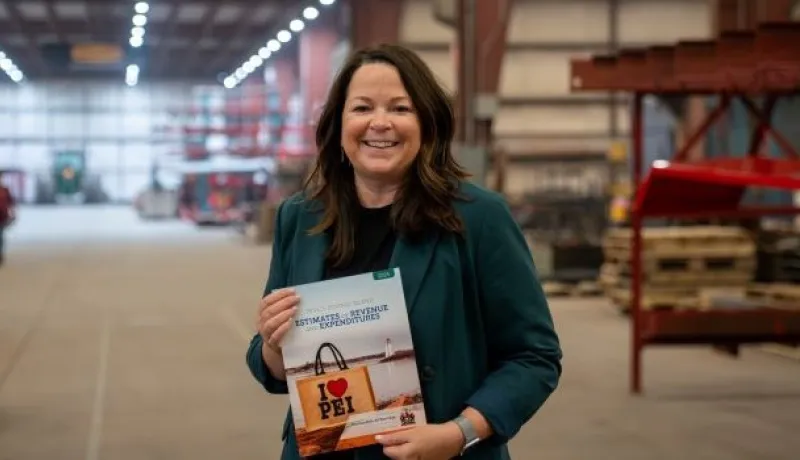 Minister Jill Burridge holding a copy of the 2026-2026 Operating Budget