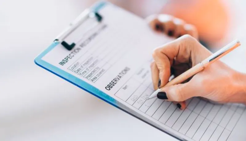 person writing on a clipboard