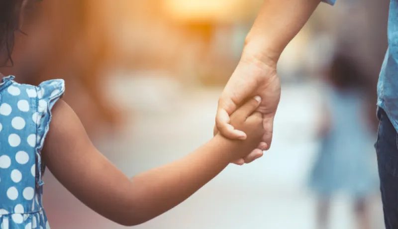 child and adult holding hands