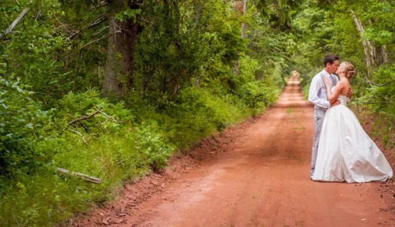 Bride and groom on red dirt road in PEI