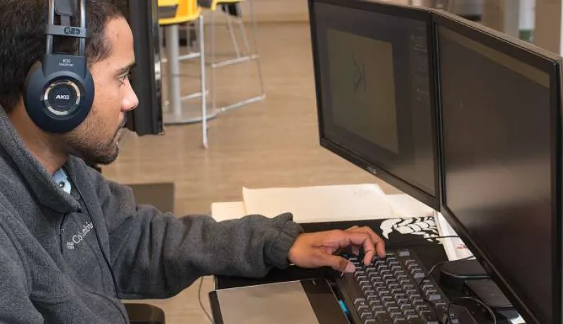 Young male works on computer