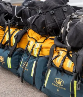 Des sacs de pompiers de brousse jaunes et verts de l'Île-du-Prince-Édouard photographiés ensemble.