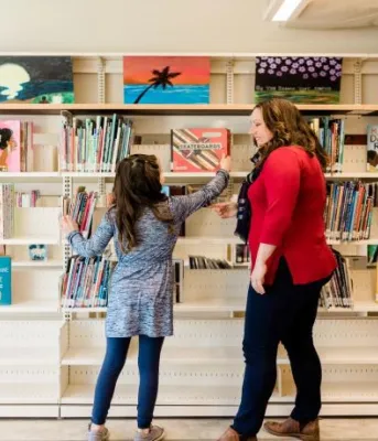 Family browsing books at library