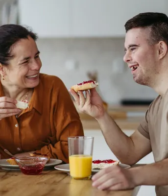 Two adults eating breakfast. 