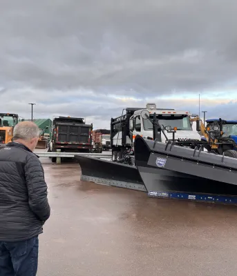 Transportation and Infrastructure Minister Ernie Hudson and Director of Highway Maintenance Stephen Szwarc at the Queens County Highway Depot looking at a new provincial snow plow.