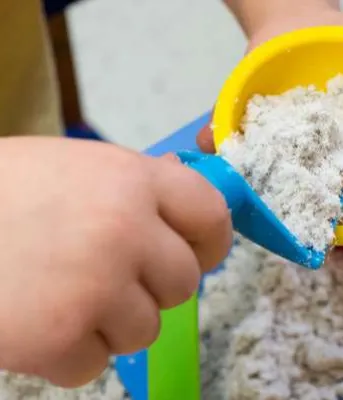Image of a child&#039;s hand playing in a sand table