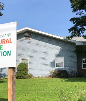 sign outside of grey building 