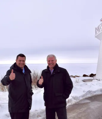 Another record-breaking year for visitation and tourism revenues Two people standing shoulder to shoulder on a wharf