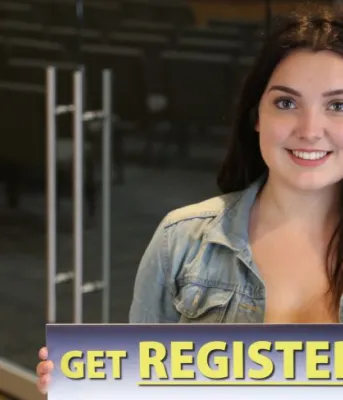 Young people aged 16 and 17 must register to vote Young woman holding sign that reads "Get Registered PEI" for PEI plebiscite on electoral reform