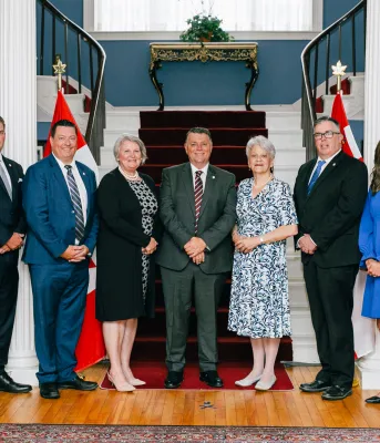 Premier King announces changes to provincial Cabinet image of some people standing shulder to shoulder in front of an indoors staircase