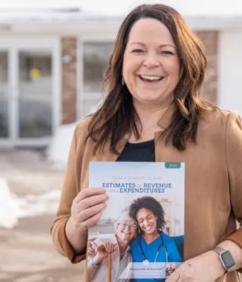 Budget 2024 signals continued focus on healthcare, housing and affordability for all Islanders image of a person outside of a building holding a document in front of her