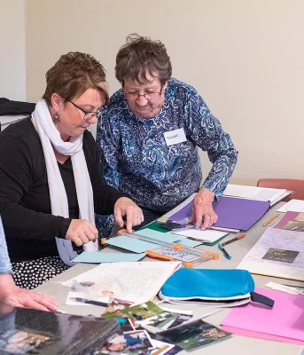 Applications being accepted for Seniors’ Secretariat grants Four people at a table working on scrapbooks