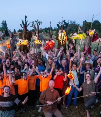 image of a group of people with hands held high in a field