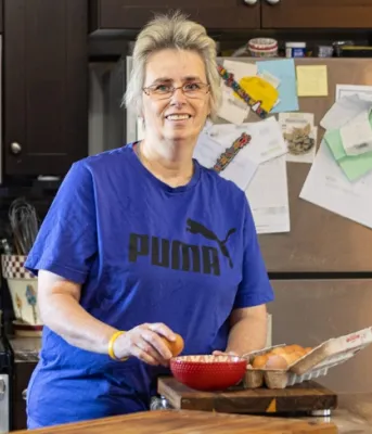 image of a person standing in a kitchen preparing some food