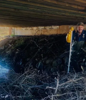 image of a person tending to a beaver dam