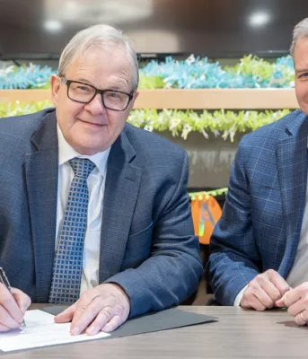 Lawrence MacAulay and Mark McLane sit at a table smiling at the camera.