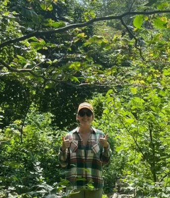 image of a person standing in some thick bushes and forest