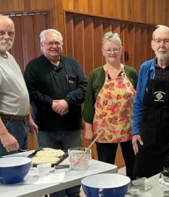 Members stand behind a cooking counter from the Benevolent Irish Society Taste of Irish Baking class