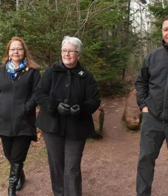 Bonshaw trail naming honours Mi’kmaq heritage Minister Biggar and two other people walking near newly neamed trail in Bonshaw.