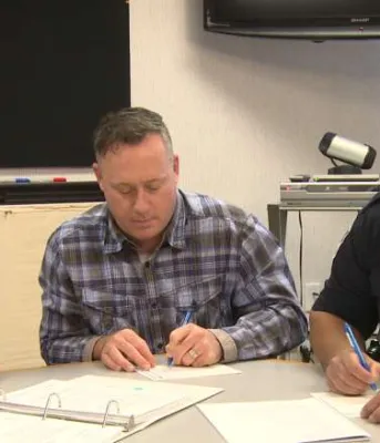 Bridge model connecting Islanders at risk of harm to programs and services Three people sitting at a table