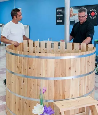 Locally made cedar hot tubs heating up in PEI (L to R): Blaine Richards, owner and operator of Richards Total Pool Services shows Minister Heath MacDonald, Economic Development and Tourism an Island-made cedar hot tub. The new cedar tubs are a one-of-a-kind product now available on PEI