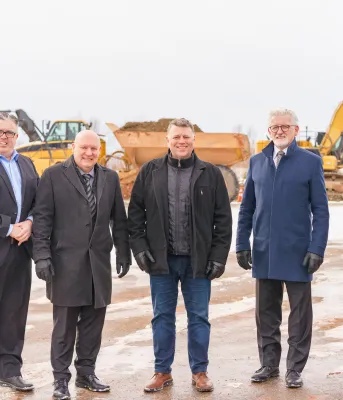 Breaking ground at Georgetown Clean Tech Park image of a group of people standing shoulder to shoulder with building equipment in the background