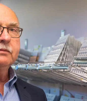 Islanders with vision loss have more drug-cost help Photo shows David Hilchey standing in front of pharmaceutical shelves.