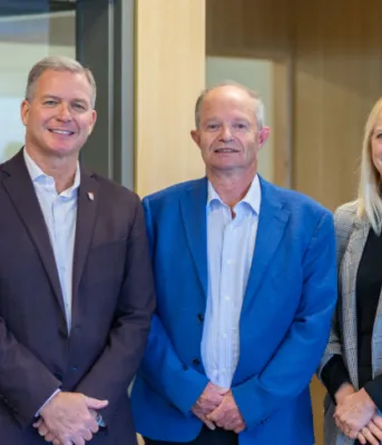 Province prepares for smooth transition of Health PEI leadership image of three people standing shoulder to shoulder in a room with a wall behind them