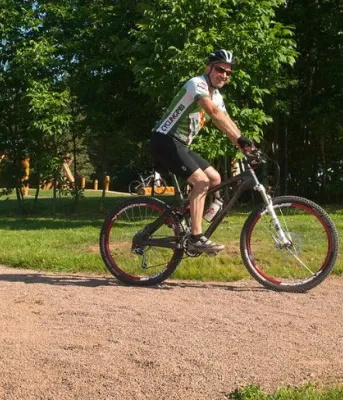 Cycling safely into summer image of two people on mountain bikes on a trail.