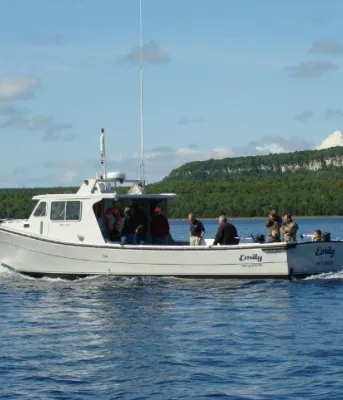 A boat, built by Provincial Boat and Marine Ltd, sails on clear blue water on a beautiful summer day. 