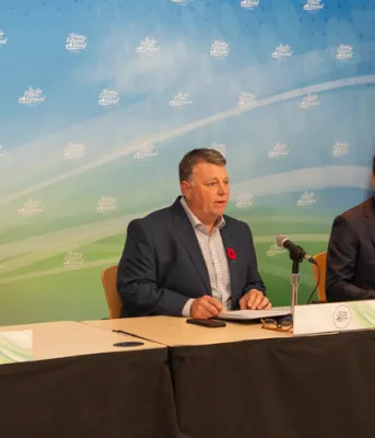 image of three people sitting at a table with microphones in front of them
