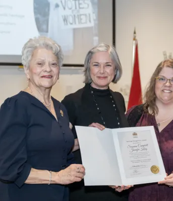 image of three people standing shoulder to shoulder and holding a certificate