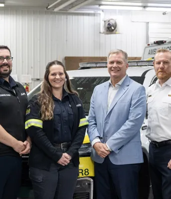 EMS workers and the Minister pictured in front of EMS vehicles