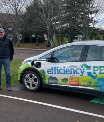 two people standing by the electric charger while charging their car