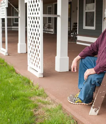 New funding will improve seniors homes Man sitting in a chair on the veranda of a seniors building