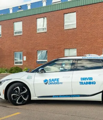 Province encouraging Islanders to try out an EV this summer image of an electric vehicle in the parking lot of a brick building in the background