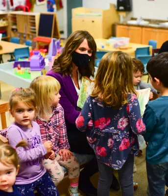 More early childhood centres receive Early Years Centre Designation image of some adults and children sitting in a classroom reading area