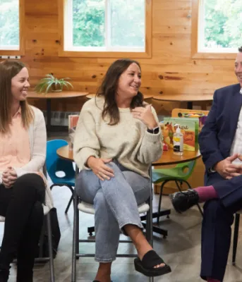 image of five adults sitting on chairs in a daycare centre