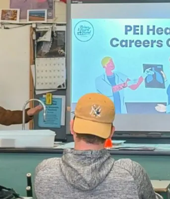 Les étudiants sont assis dans une salle de classe en train d'écouter la présentation.