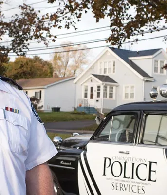 Photo shows Gary McGuigan standing next to Charlottetown Police Services&#039; classic patrol car.